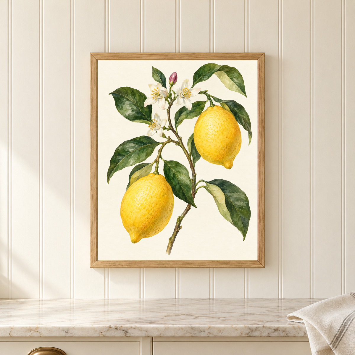 Lemon Blossom Study botanical print in an oak frame on cream paneling above a marble kitchen counter.